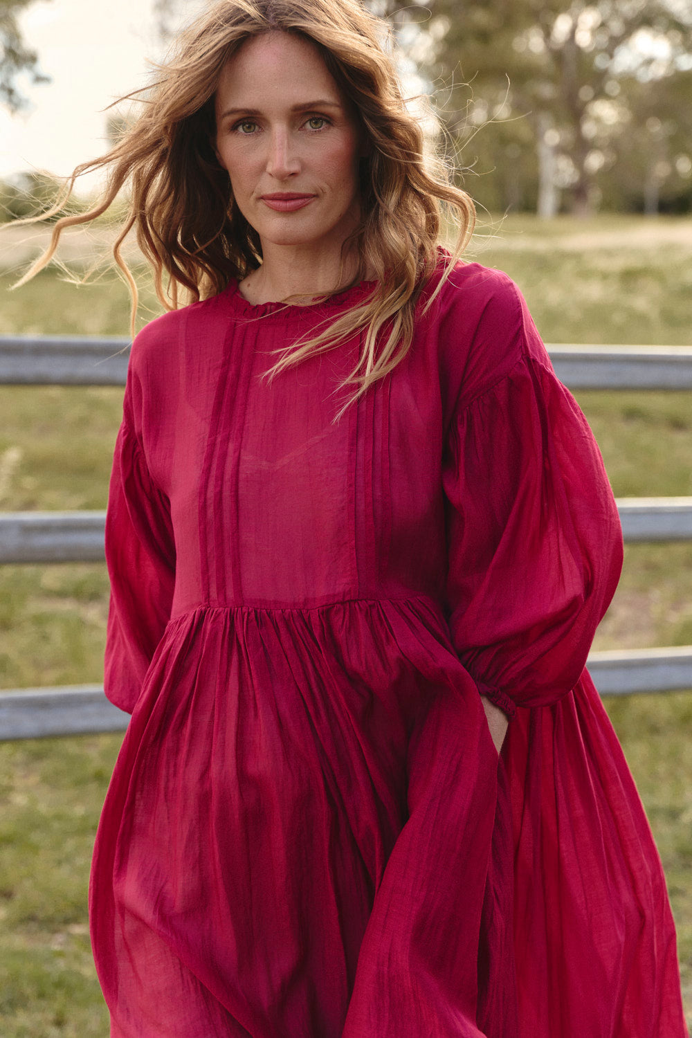 Model wearing the Coco Cotton Silk Dress in Scarlet with long gathered billow sleeves, Adrift Clothing