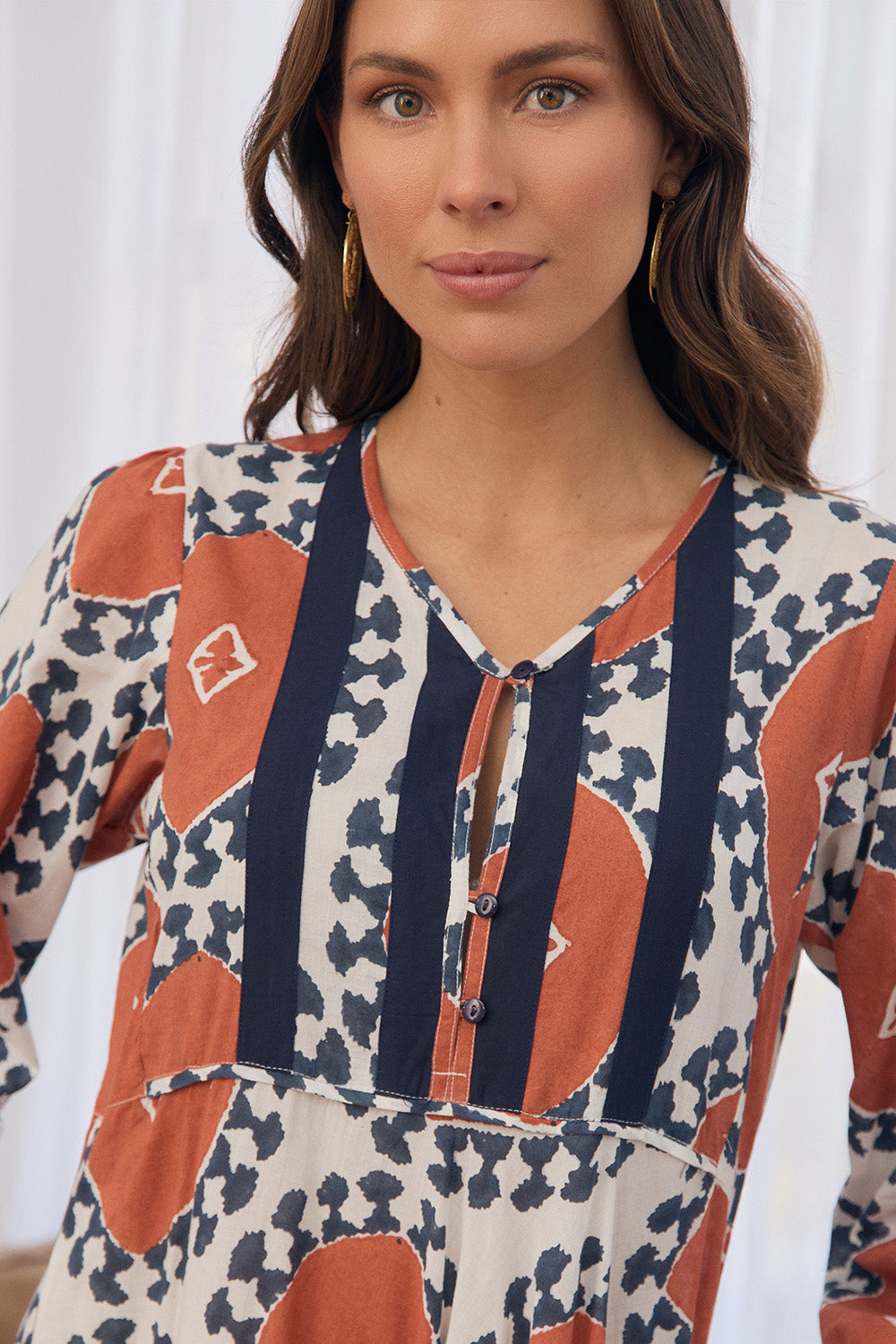 Woman wearing a patterned dress with orange and blue design